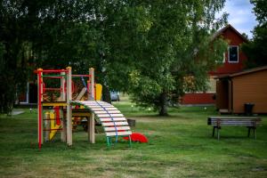 a playground with a slide in a park at Kempings Stieres un Mājas Virtuve in Upesgrīva