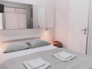 una camera da letto con un letto con due asciugamani sopra di Atrijum apartmani Apatin a Apatin