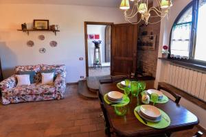 a living room with a table and a couch at Appartamento Le Macine in Isola d'Arbia