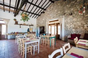 a restaurant with tables and chairs and a stone wall at Agriturismo Ristorante Monte Argentario in Monte Argentario