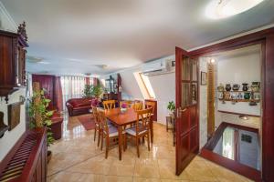 a dining room and living room with a table and chairs at Tamás Apartman Balatonföldvár szívében- egész évben nyitva! in Balatonföldvár