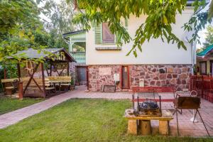 a stone house with a grill in the yard at Tamás Apartman Balatonföldvár szívében- egész évben nyitva! in Balatonföldvár