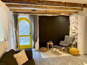 a living room with a couch and a chair and a window at Bell Tower House in Novi Vinodolski