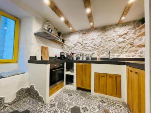 a kitchen with a stone wall and a counter top at Bell Tower House in Novi Vinodolski