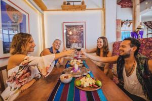 un grupo de personas sentadas alrededor de una mesa bebiendo vino en Baraka Atitlán en San Marcos La Laguna