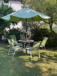a table with four chairs and an umbrella at Casa Silvia in Gordevio