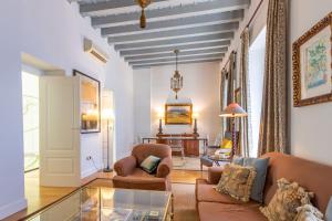 uma sala de estar com um sofá e uma mesa em Museum Duplex and Patios, Historical Center, 8 pax em Sevilha