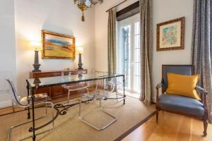 a dining room with a glass table and two chairs at Museum Duplex and Patios, Historical Center, 8 pax in Seville