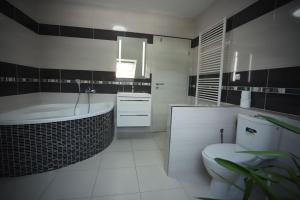 a bathroom with a tub and a toilet and a sink at Apartmán TINA in Rudolfov