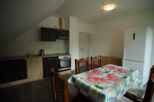 a kitchen with a table and a white refrigerator at Apartmán TINA in Rudolfov