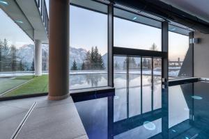 a swimming pool in a building with a view of the mountains at Panorama Hotel Fontanella in Madonna di Campiglio