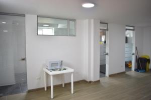 um quarto com uma mesa branca e um micro-ondas em La Puerta Rota em Zipaquirá