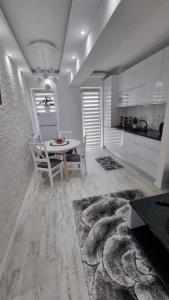 a kitchen and dining room with a table and chairs at Apartament Alina Sunrise in Saturn