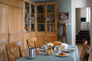 uma mesa com comida numa sala de jantar em Contes à Rebours - Chambres d'hôtes em Morlaix