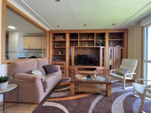 a living room with a couch and a tv at Apartamento Arao Malpica con vistas al mar in Malpica