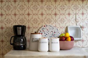 a counter with three coffee mugs and a bowl of fruit at Kilada Country House in Kilada