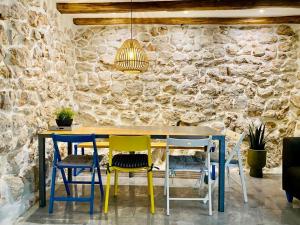 a table and chairs in a room with a stone wall at Bell Tower House in Novi Vinodolski