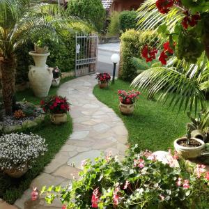 un jardin avec des plantes en pot et des fleurs dans une cour dans l'établissement Luxury Portorosa villa, à Furnari