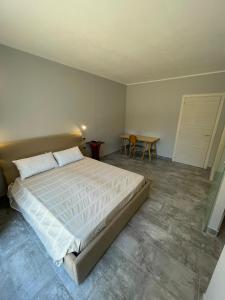 a bedroom with a large bed and a table at Casa Camere Pistis in Assemini