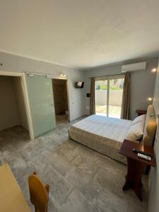 a bedroom with a bed and a desk and a window at Casa Camere Pistis in Assemini