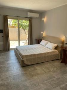 a bedroom with a large bed and a large window at Casa Camere Pistis in Assemini