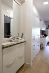 cocina blanca con lavabo y espejo en Incantevole appartamento Taormina, en SantʼAlessio Siculo