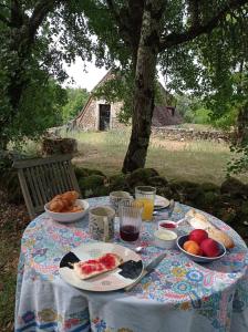 uma mesa com pratos de comida e fruta em Gîte d'Espinières em Orniac