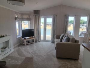 un soggiorno con divano e TV di Remarkable 2-Bed Luxury Lodge in Routh with hottub a Routh