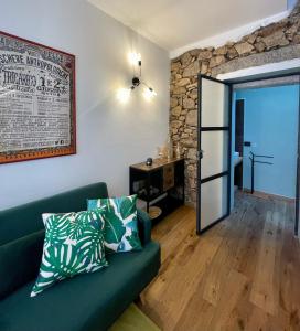 a living room with a green couch and a stone wall at Suite 29A Olbia Center in Olbia