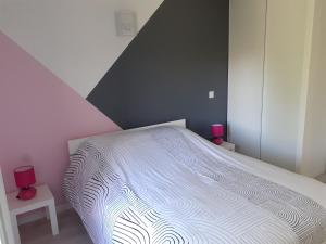 een slaapkamer met een bed met een wit dekbed bij la bonne tuile 
