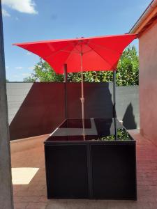 een rode paraplu bovenop een tafel bij la bonne tuile 