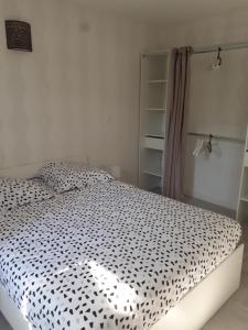 een slaapkamer met een bed met een zwart-wit dekbed bij la bonne tuile 