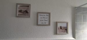 drie foto's hangen aan een muur met een aigrafiebord bij Küstenliebe in Wilhelmshaven +12 foto's