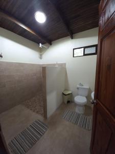 a bathroom with a shower and a toilet in it at Hotel Catarata Río Celeste in Bijagua