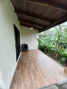 a room with a wooden floor and a chair at Hotel Catarata Río Celeste in Bijagua