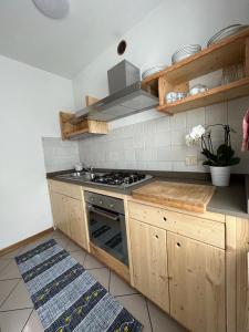 a kitchen with wooden cabinets and a stove top oven at DOLOMITI HOUSE 2 in Fiera di Primiero