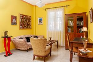 a living room with yellow walls and a table and a couch at Stavros summer house in Nea Fokea
