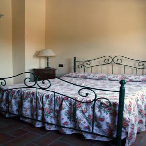 a bedroom with a bed with a floral bedspread at Agriturismo La Cicala in Carassai