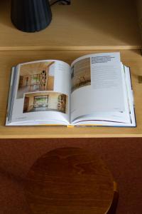 an open book on a desk with a wooden table at Upea studioasunto historiallisella Hangon Asemalla in Hanko