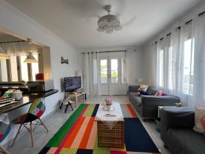 Lazorde Beachfront Experience في العلمين: غرفة معيشة مع أريكة زرقاء وسجادة ملونة