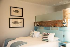 a bedroom with a bed and a brick wall at Whalesong Lodge in Gansbaai