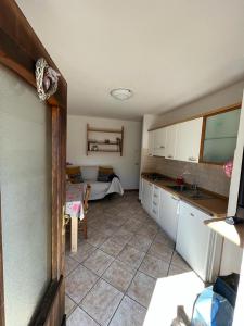a kitchen with a sink and a table in a room at DOLOMITI house 1 in Fiera di Primiero