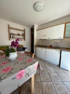 a kitchen with a table with a vase of flowers on it at DOLOMITI house 1 in Fiera di Primiero