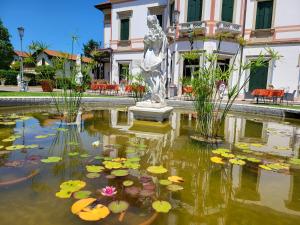 a pond with a statue in front of a building at Hotel Villa Stucky in Mogliano Veneto