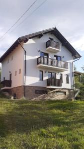 Una casa blanca con balcones en un lateral. en Vila Hojda, en Moisei