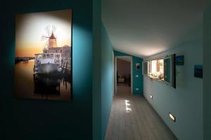 a hallway with a painting of a windmill on the wall at Brezza Salina in Torre Nubia