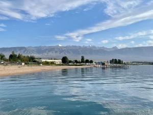 ein Wasserkörper mit Bergen im Hintergrund in der Unterkunft Raduga West_Issyk Kul, Kyrgyzstan in Koshkolʼ