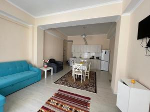 a living room with a blue couch and a table at Raduga West_Issyk Kul, Kyrgyzstan in Koshkolʼ