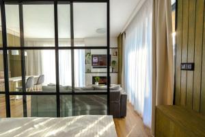a bedroom with a bed and a glass wall at HILLHOME apartment & Sauna in Donovaly