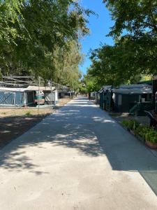 an empty road with tents and trees on either side at KT-0094 Magnífica Tienda Tipi - Camping Miramar Playa in Torredembarra